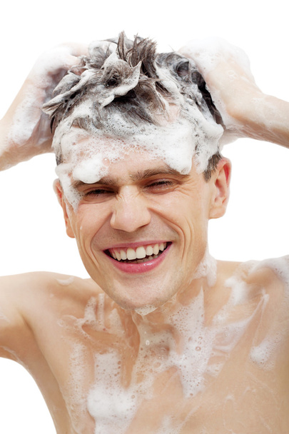 γυμνός άνδρας με σαμπουάν για μαλλιά στο ντους που απομονώνονται σε λευκό φόντο. - Φωτογραφία, εικόνα
