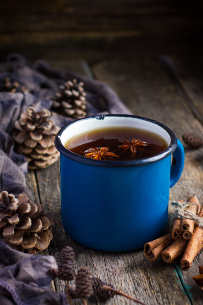 Hot spicy tea with anise and cinnamon in vintage blue enamel mug - Photo, image