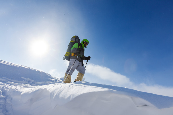 Backpacker mężczyznę idącego w górach zimą na słoneczny dzień - Zdjęcie, obraz