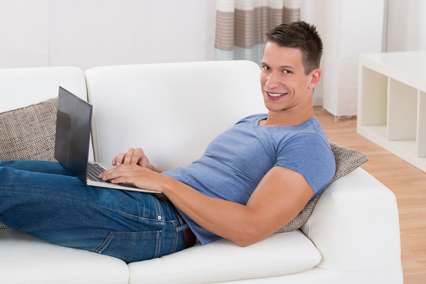 Man Using Laptop In Living Room - Фото, зображення