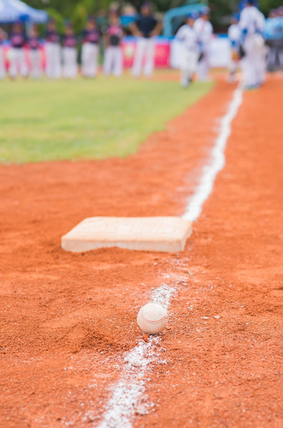 бейсбол і база на бейсбольному полі з гравцями, що практикуються на фоні
 - Фото, зображення