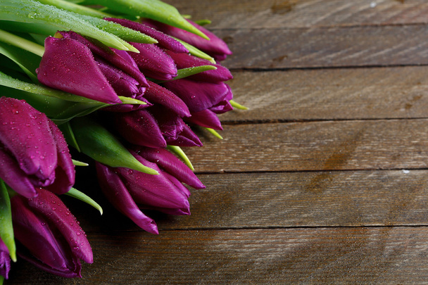 Purple tulips on brown boards - Foto, afbeelding