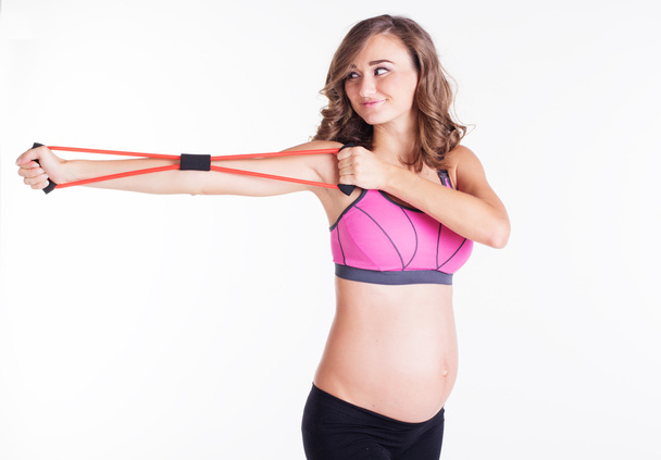 Zwangere vrouw sport met weerstand banden buis doet - Foto, afbeelding