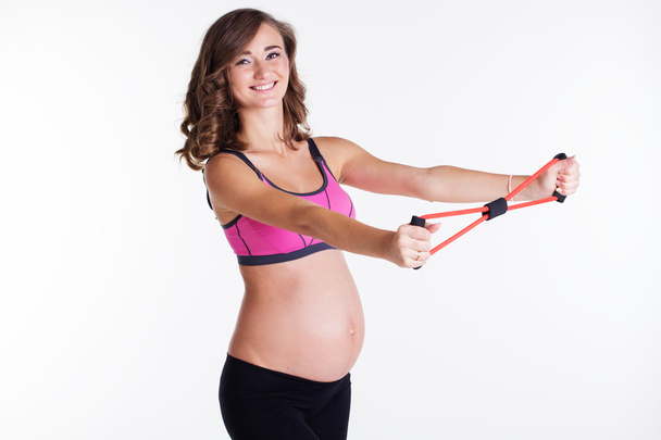 Pregnant woman doing pilates with rubber band - Fotó, kép
