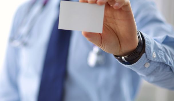 un médecin masculin montre une carte de visite
 - Photo, image