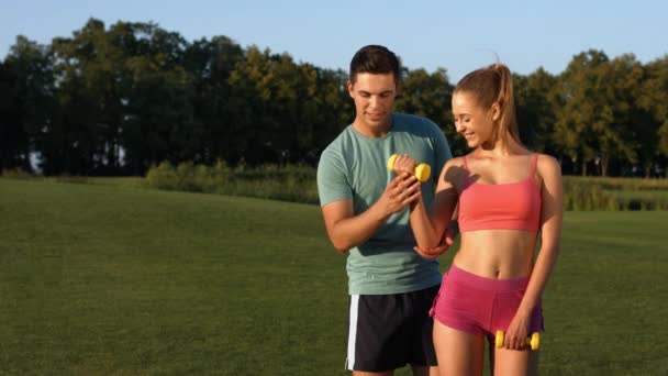 Sports trainer engaged in sports with a girl in the park. - Πλάνα, βίντεο