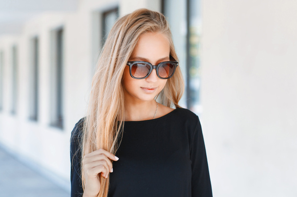 Beautiful girl in sunglasses on background of windows - Zdjęcie, obraz