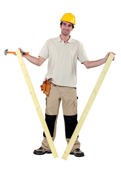 Worker holding two planks of wood - Фото, зображення