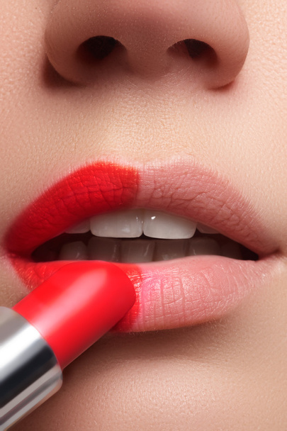 Extreme close up on model applying red lipstick. Makeup. Professional fashion retro make-up. Red lipstick. - 写真・画像