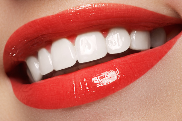Primo piano sorriso femminile felice con denti bianchi sani, trucco labbra rosso brillante. Cosmetologia, odontoiatria e bellezza. Macro della bocca sorridente della donna
 - Foto, immagini