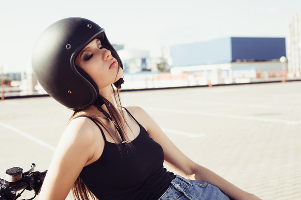Biker girl in helmet sitting on custom motorcycle - Foto, imagen