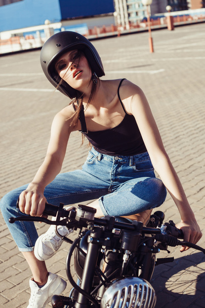Biker girl sitting on vintage custom motorcycle - Fotografie, Obrázek