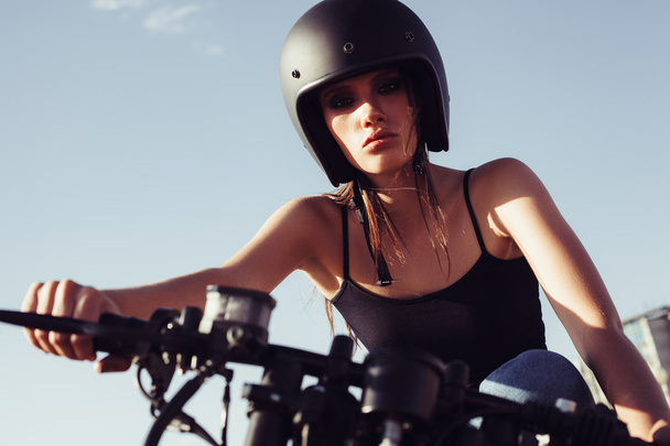 Biker girl sitting on vintage custom motorcycle - Foto, imagen