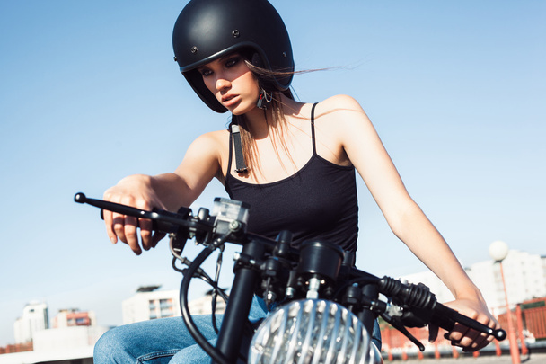 Pyöräilijä tyttö istuu vintage custom moottoripyörä
 - Valokuva, kuva