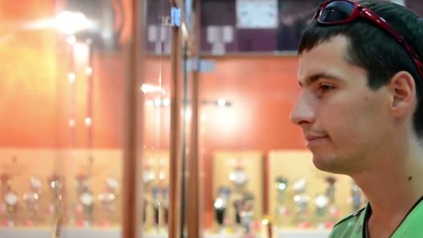νεαρό άτομο που στέκεται κοντά τα παράθυρα στο κατάστημα - Πλάνα, βίντεο