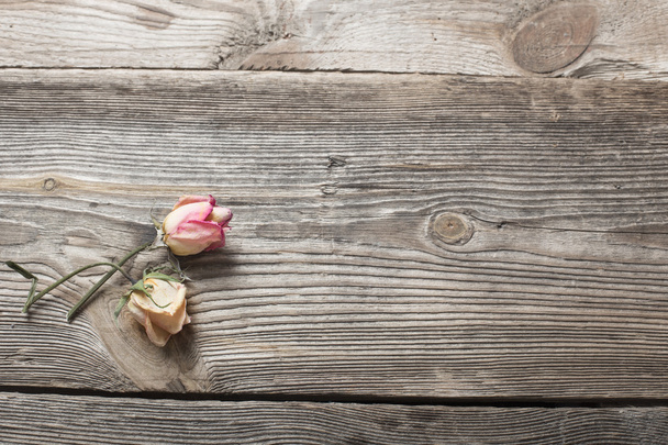 dried rose petals on wooden table - Foto, afbeelding