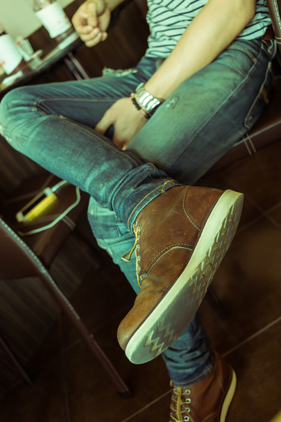 коричневые сапоги кожаные туфли и джинсовые брюки одежда человека
 - Фото, изображение