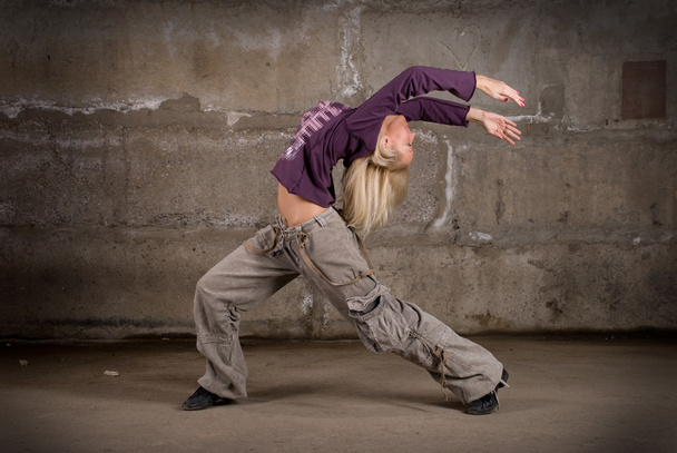 Beautiful hip hop girl dancing over grey brick wall - Foto, Imagem