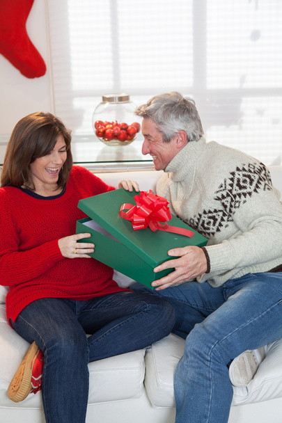 Жінка відкриває подарунок чоловікові
 - Фото, зображення