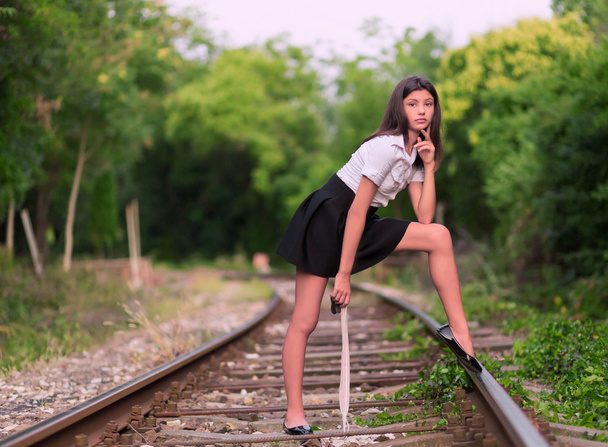 Chica posando en la línea ferroviaria
 - Foto, imagen