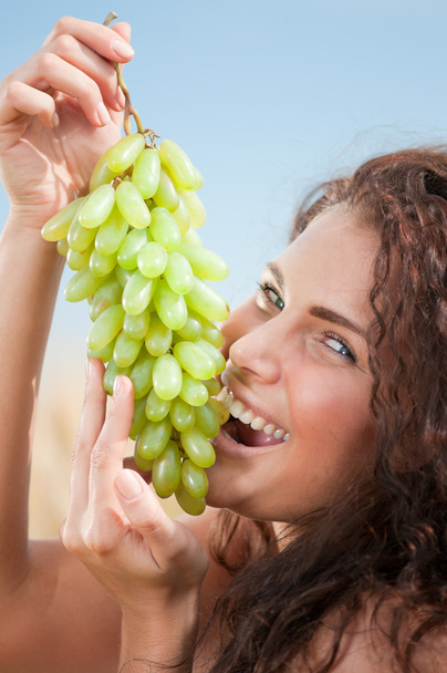 Perfect woman eating grapes in wheat field. Picnic. - Φωτογραφία, εικόνα