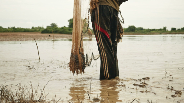  pescador de pie junto al río en busca de un buen lugar para lanzar la red
 - Metraje, vídeo