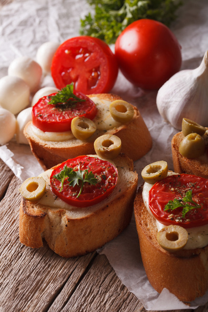 Crostini com tomates assados, azeitonas e queijo close-up. verticária
 - Foto, Imagem