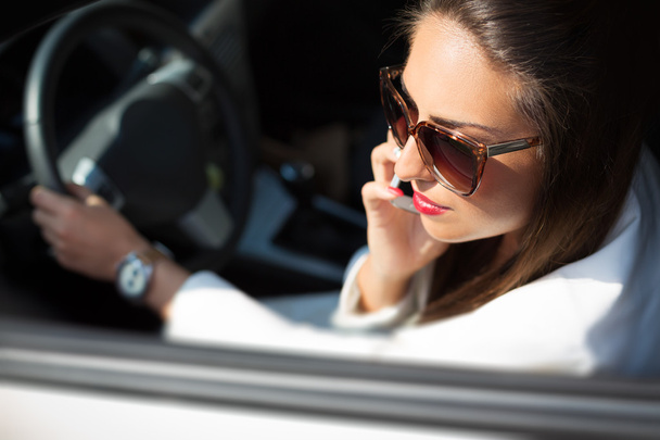 Young businesswoman on the phone in her car - Фото, изображение