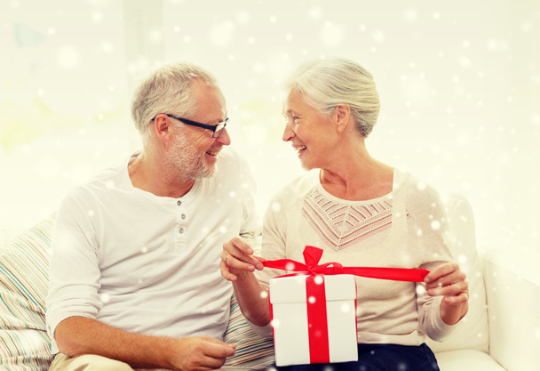 happy senior couple with gift box at home - Foto, Imagem