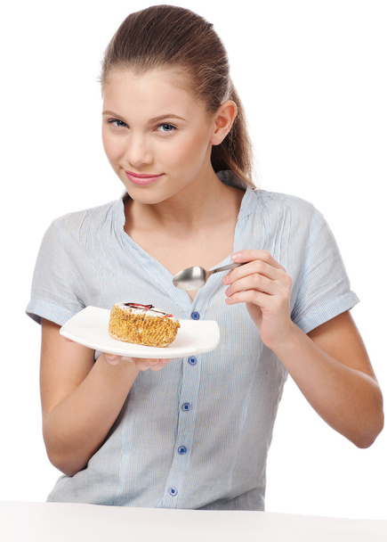 Pretty young woman eating cake. Isolated - Fotoğraf, Görsel