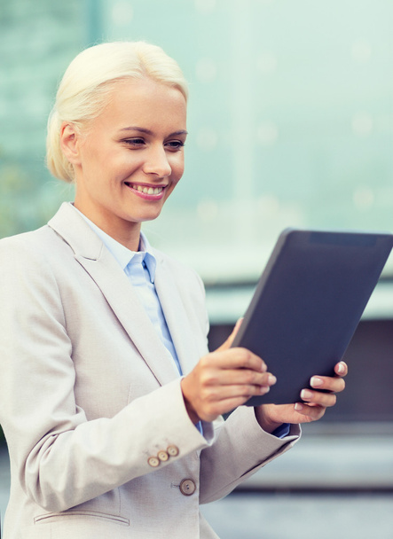 smiling businesswoman with tablet pc outdoors - Foto, afbeelding