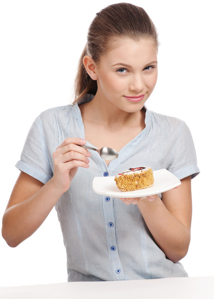Pretty young woman eating cake. Isolated - Photo, Image
