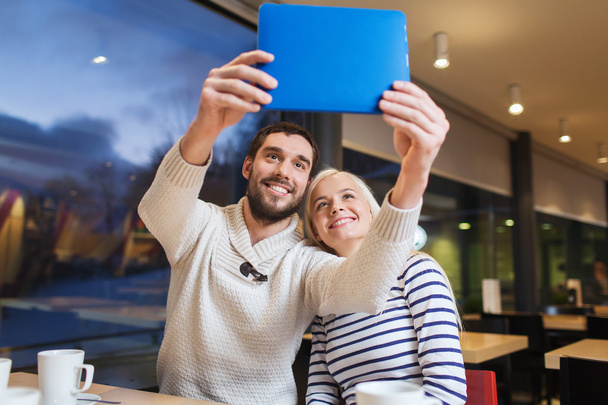 happy couple with tablet pc taking selfie at cafe - Фото, зображення