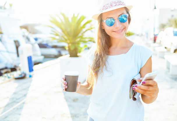 Happy young woman drinking takeaway coffee and walking on the wa - Zdjęcie, obraz