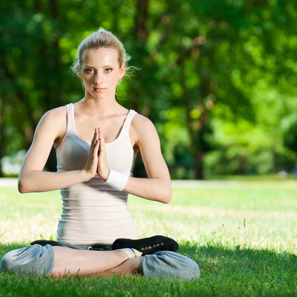 Young woman doing yoga exercise - Foto, afbeelding