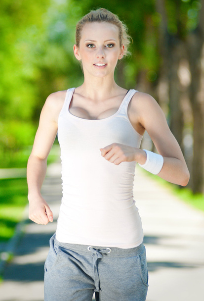 Young woman running in green park - Φωτογραφία, εικόνα