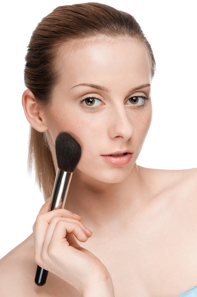Beautiful young adult woman applying cosmetic brush - Photo, Image