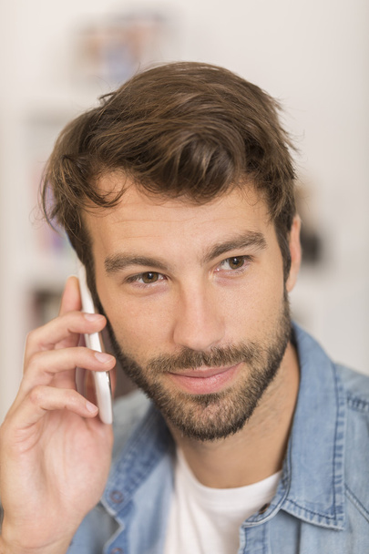 young man talking on phone at home - Foto, Imagen