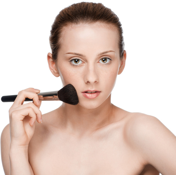 Beautiful young adult woman applying cosmetic brush - Foto, Imagen