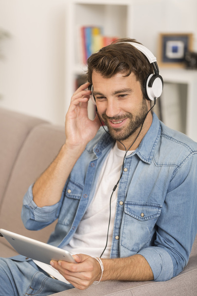young man listenig music with digital tablet at home - Foto, Imagem