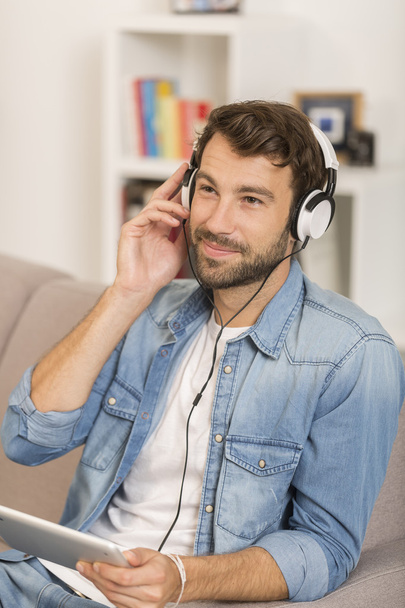 young man listenig music with digital tablet at home - Fotó, kép