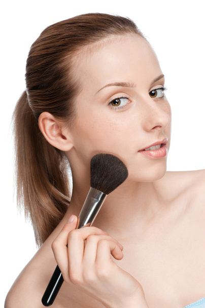 Beautiful young adult woman applying cosmetic brush - Фото, изображение