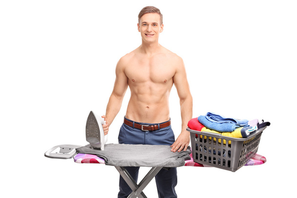 Young man behind an ironing board - Fotó, kép