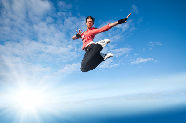 Sport woman jumping and fly over sky and sun - Foto, Imagem