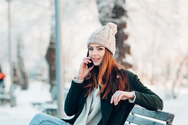 Young  woman smiling with smart phone and winter landscape . - Foto, Imagem