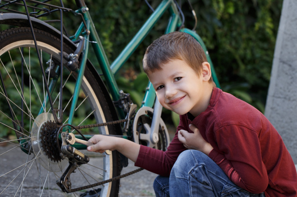Kleine jongen herstel fiets - Foto, afbeelding