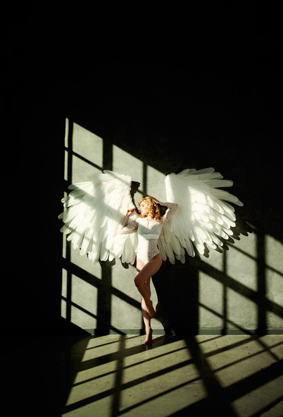 Γυναίκα με λευκά φτερά στο σκοτάδι - Φωτογραφία, εικόνα