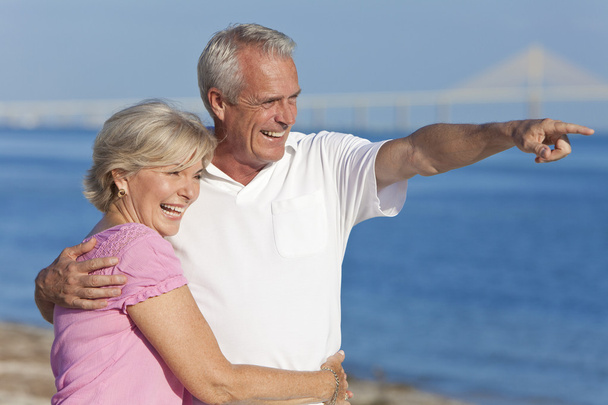Happy Senior Couple Walking Pointing on Beach - Photo, Image