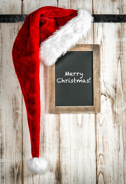 Red Santa hat and vintage chalkboard. Christmas decoration - Photo, image