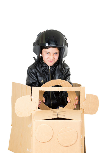 Adorabile giovane ragazzo vestito con costume da pilota seduto in una macchina di cartone che gioca isolato su sfondo bianco
 - Foto, immagini